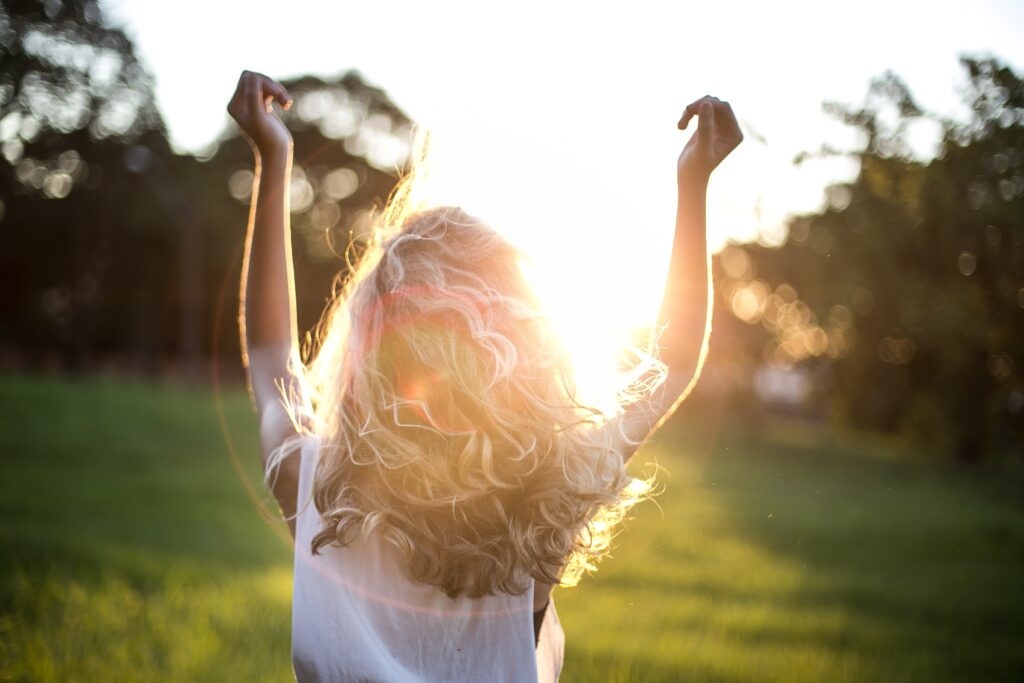 Woman holding arms out toward the sunlight