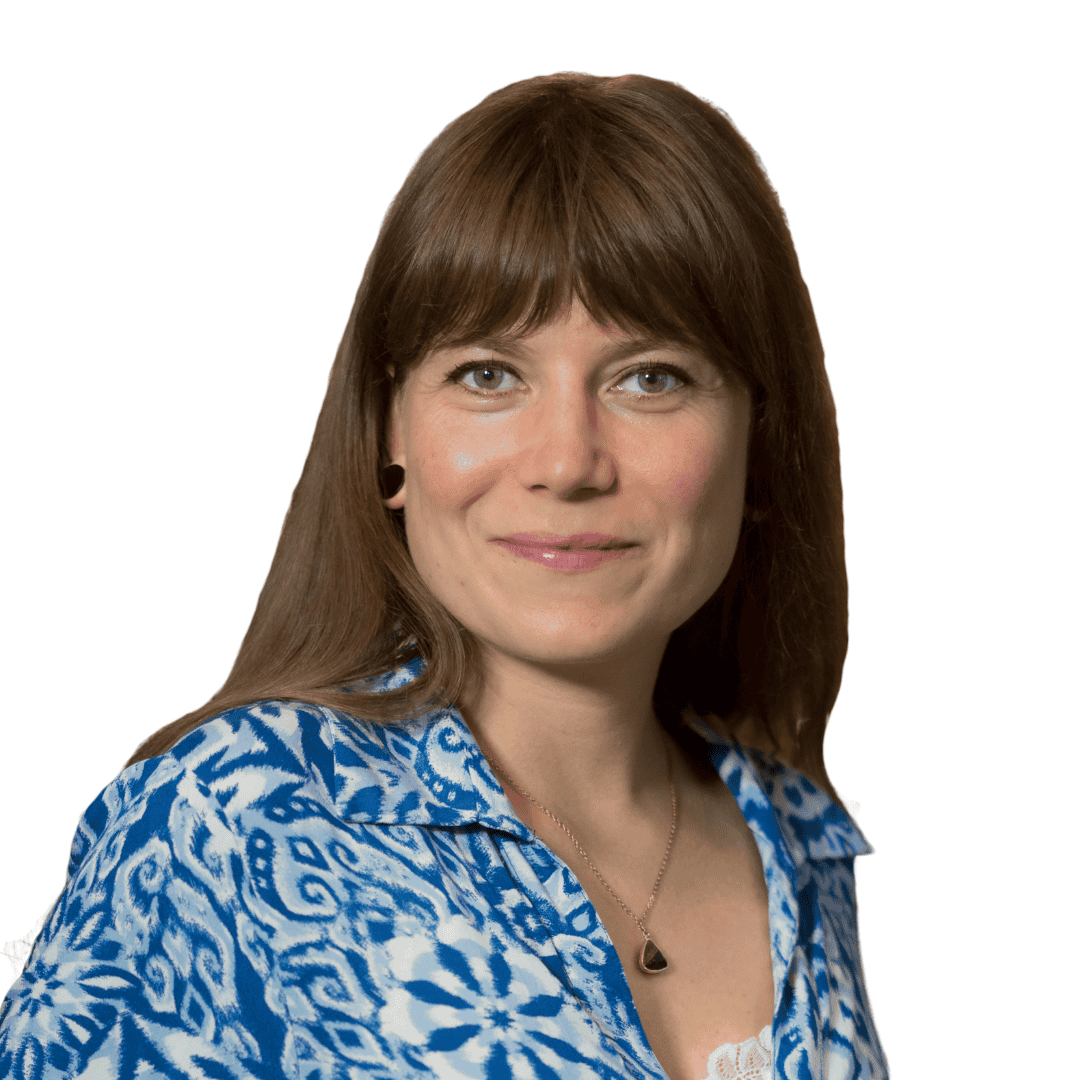 Žena s dlouhými hnědými vlasy a ofinou, oblečená v černém saku přes tmavý top, sebevědomě pózuje na bílém pozadí - ideální pro představení nového potravinářského fóra.