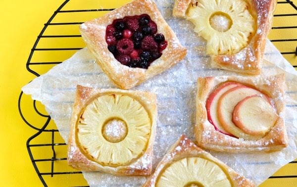 Golden puff pastry slices topped with pineapple rings and dusted with icing sugar.
