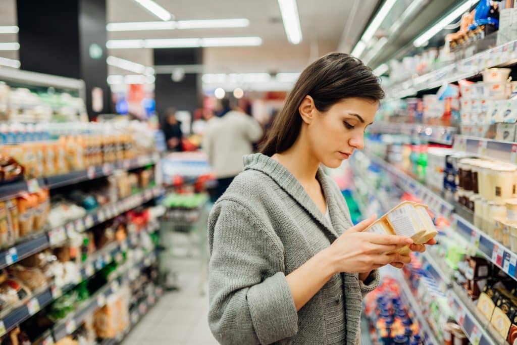 Young woman shopping in the supermarket grocery store.
